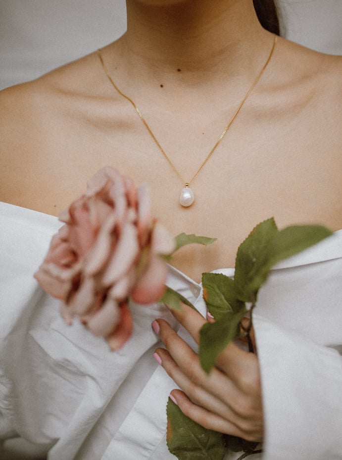 Woman with a Necklace Holding a Flower