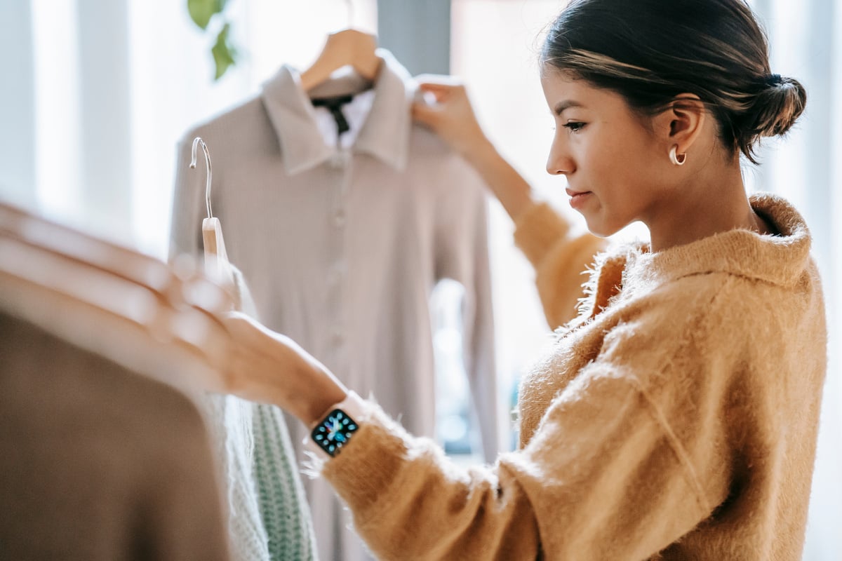 Concentrated woman with hangers and clothes